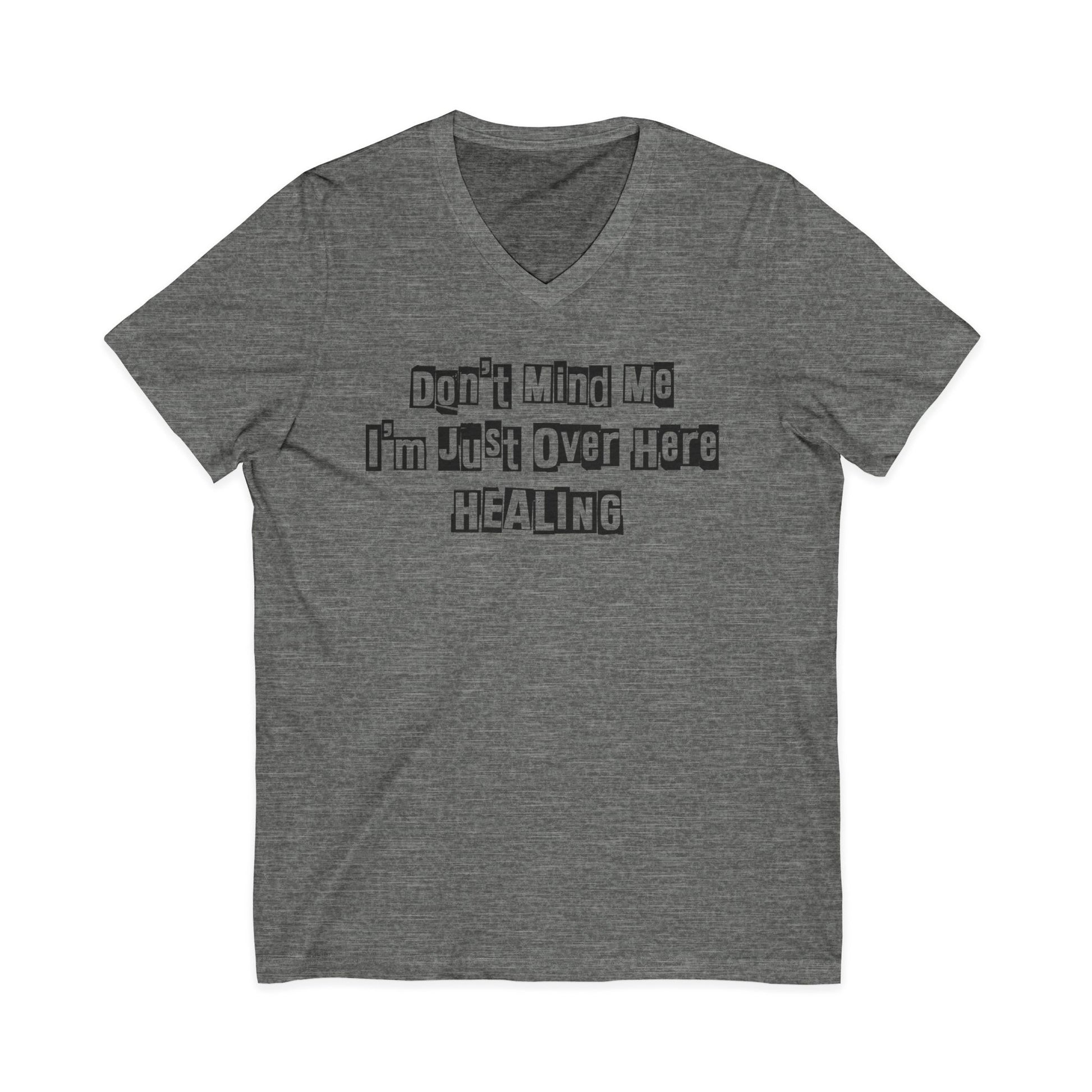 Dark heather grey JohnT V-neck T-shirt with the printed text “Don’t Mind Me I’m Just Over Here Healing” displayed flat on a plain background.