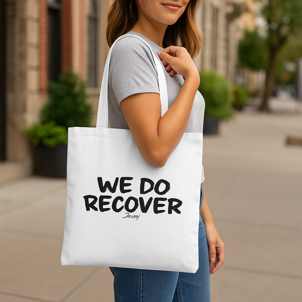 Johny-T “We Do Recover” inspirational white tote bag shown in an outdoor lifestyle mockup carried by a model.