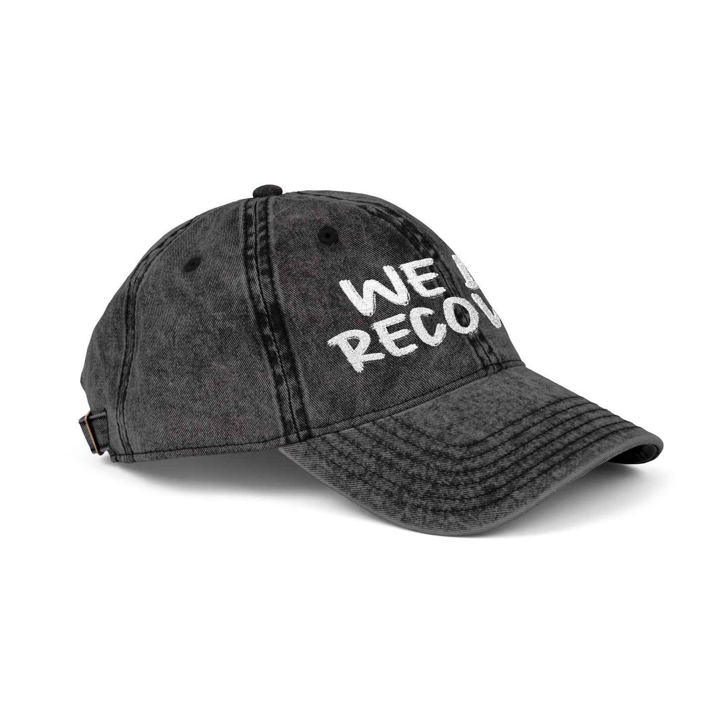 Side angle view of distressed black dad hat with white embroidered We Do Recover text, Johny-T apparel