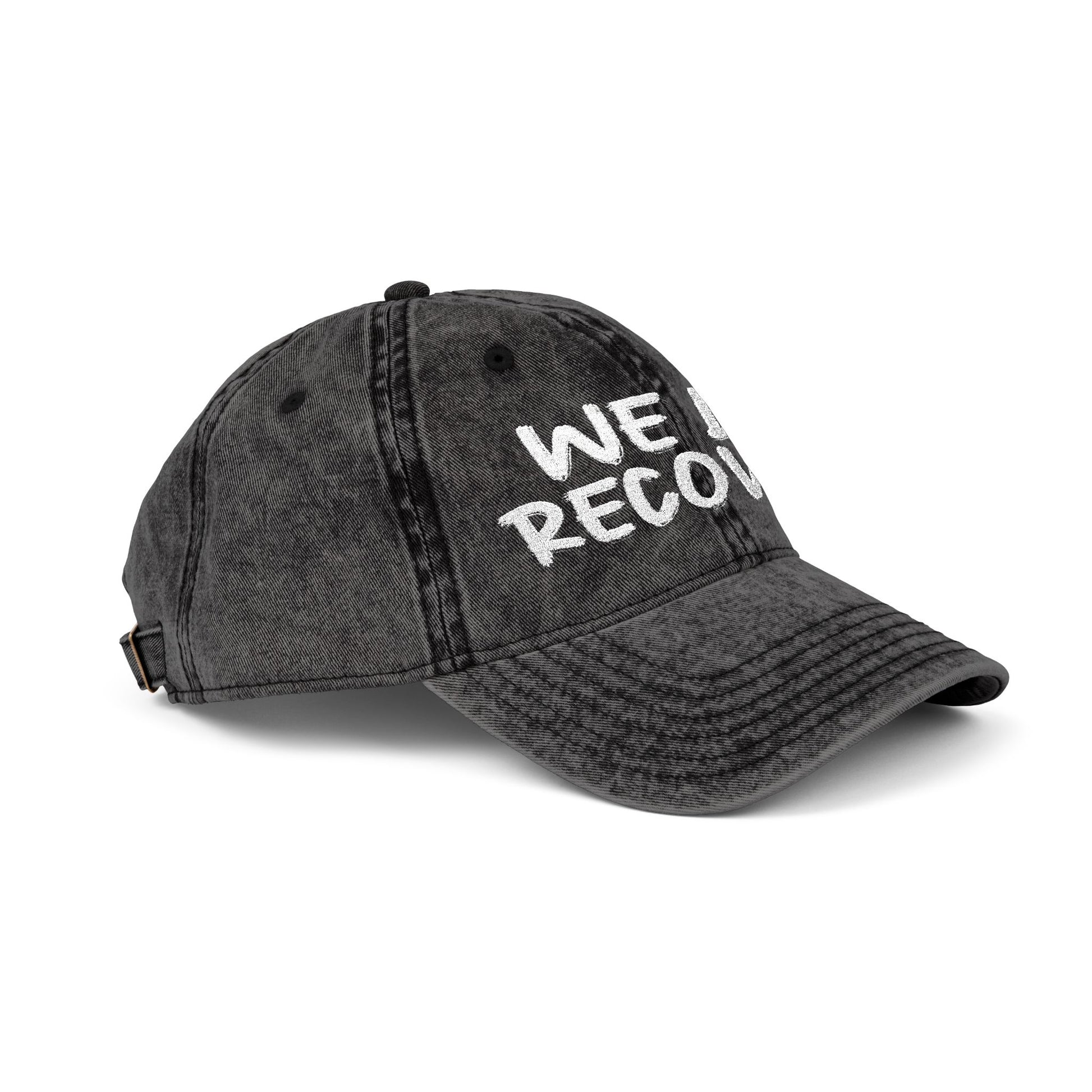 Side angle view of distressed black dad hat with white embroidered We Do Recover text, Johny-T apparel